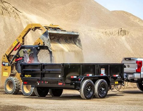 A heavy machinery loading sand onto a trailer